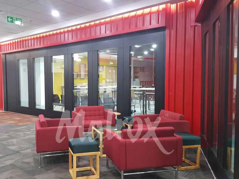 Louis acoustic glass worth itnge area with modern red sofas and black glass partitions.